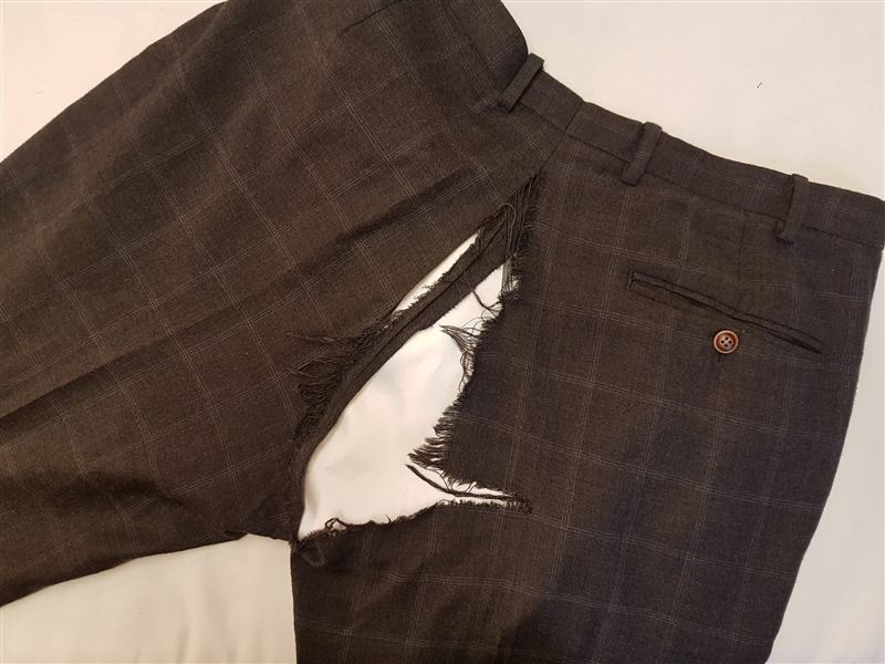Checked trousers with a torn seam, before repair